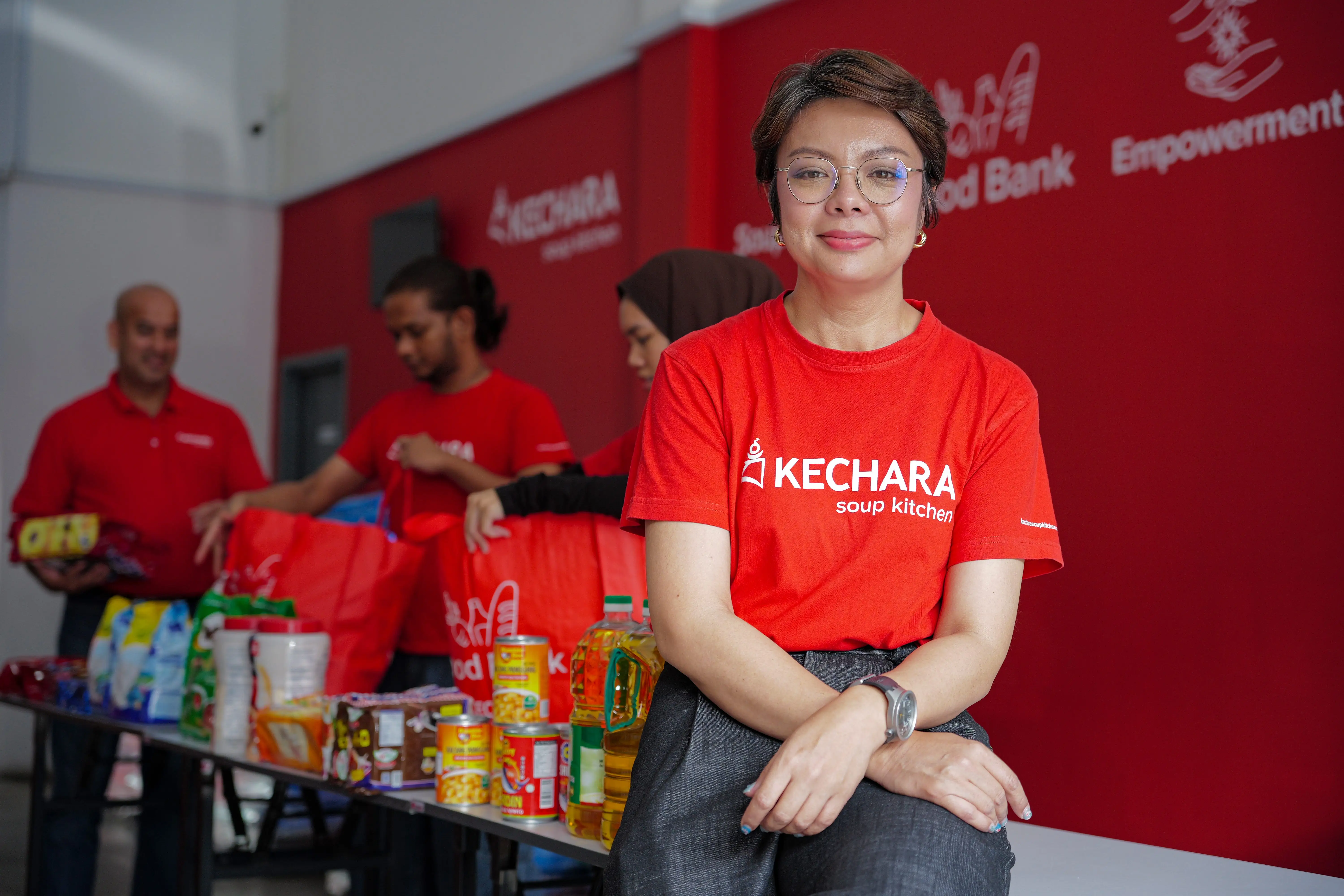 Natasya Pawanteh in. red shirt sitting on a table with food