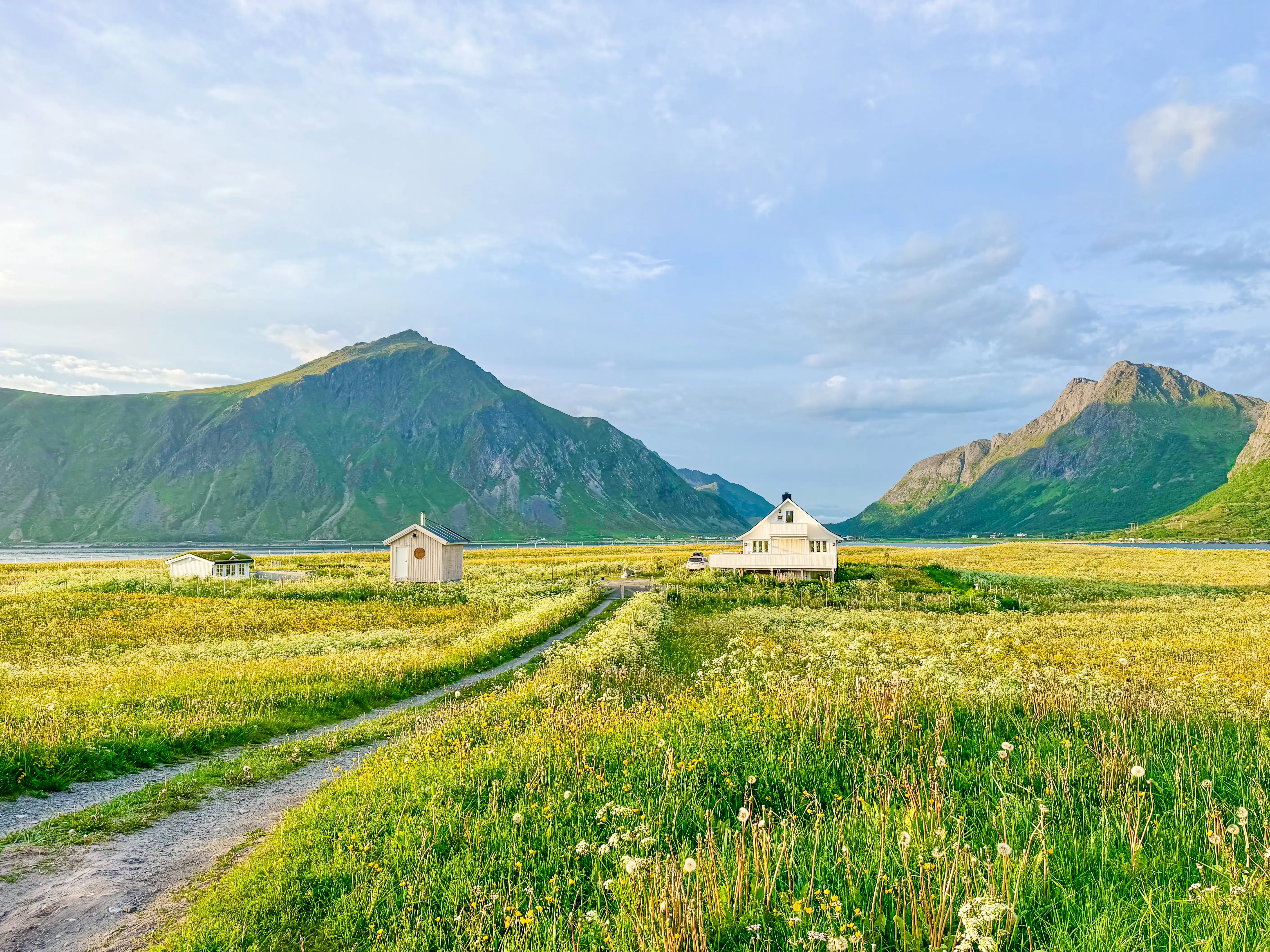 House with mountains behind it, grass in front of it
