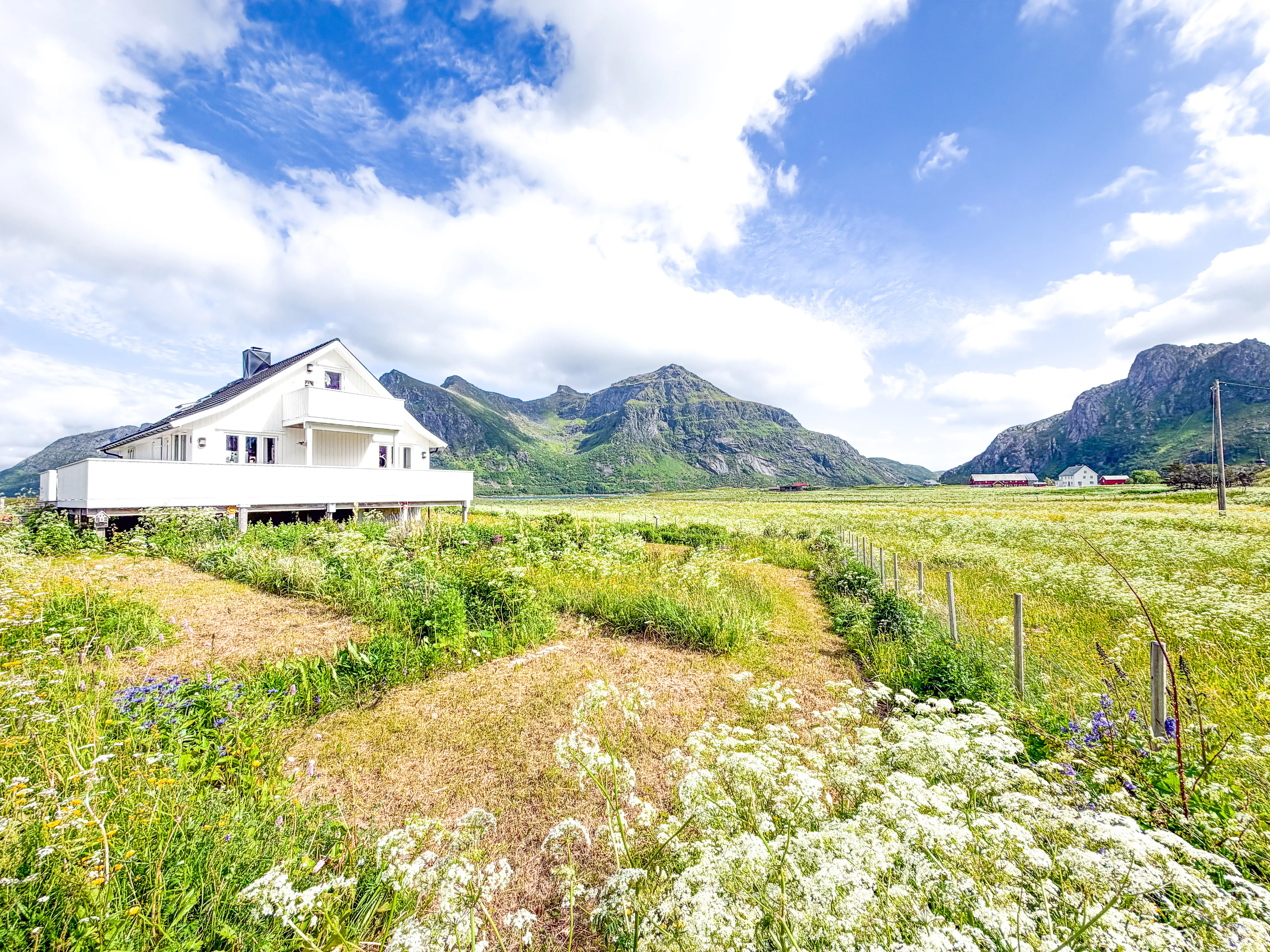 White house surrounded by grass with mountains in distance