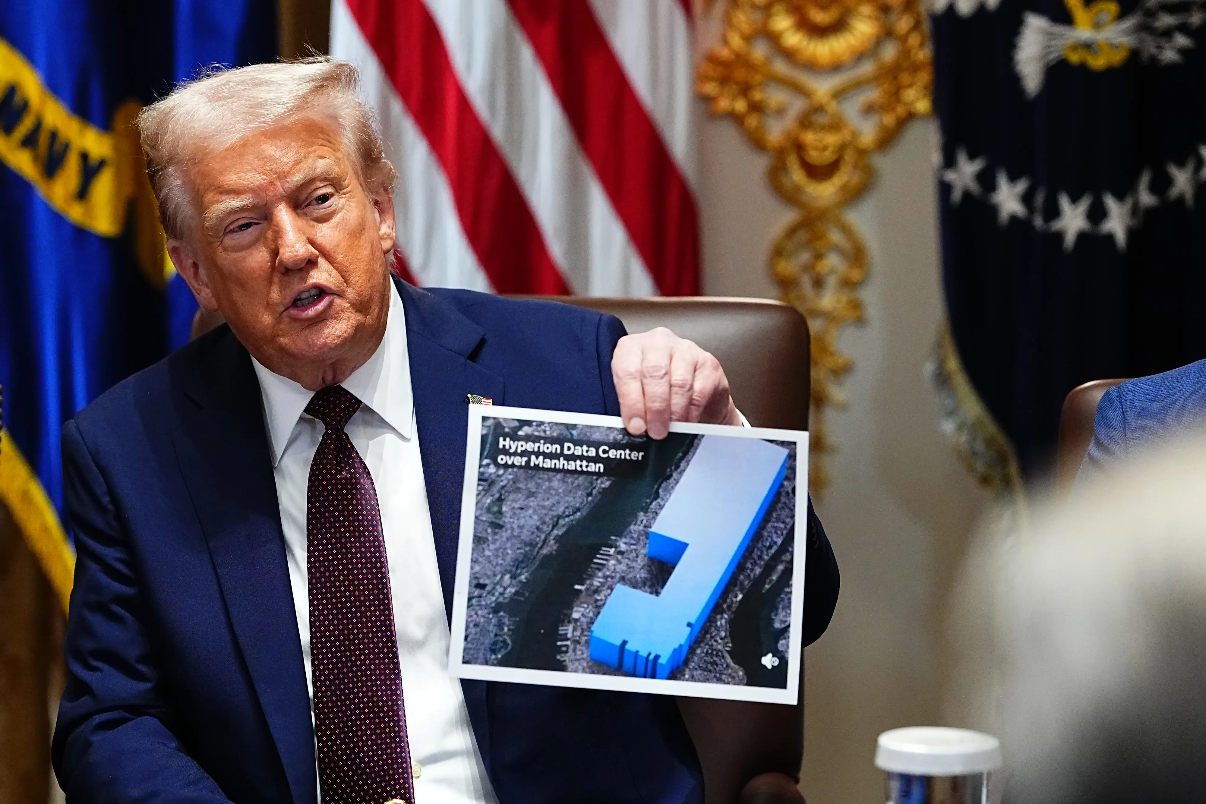 Donald Trump holds up a graphic showing the size of Meta's Hyperion Data Center