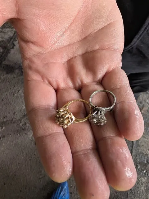 Two rings, one gold and one silver, in a person's palm.