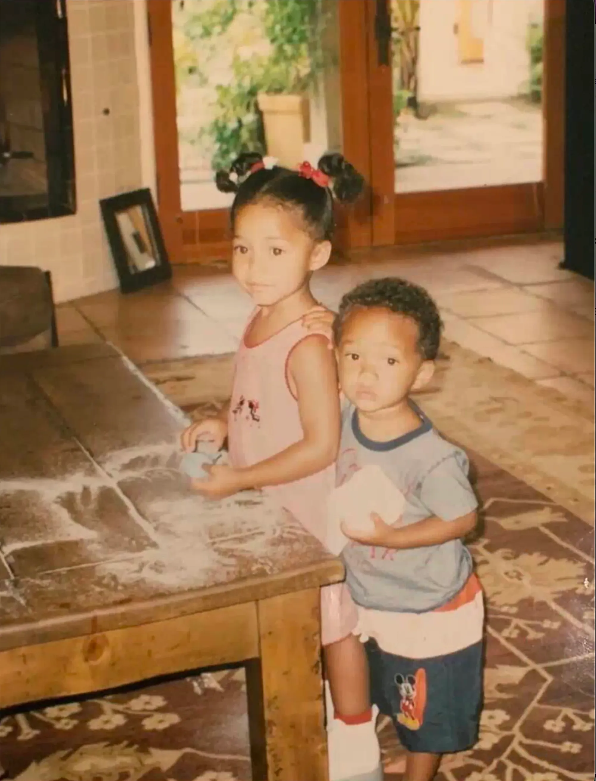 A young Jordyn Woods and Jaden Smith standing next to a table with flour on it.