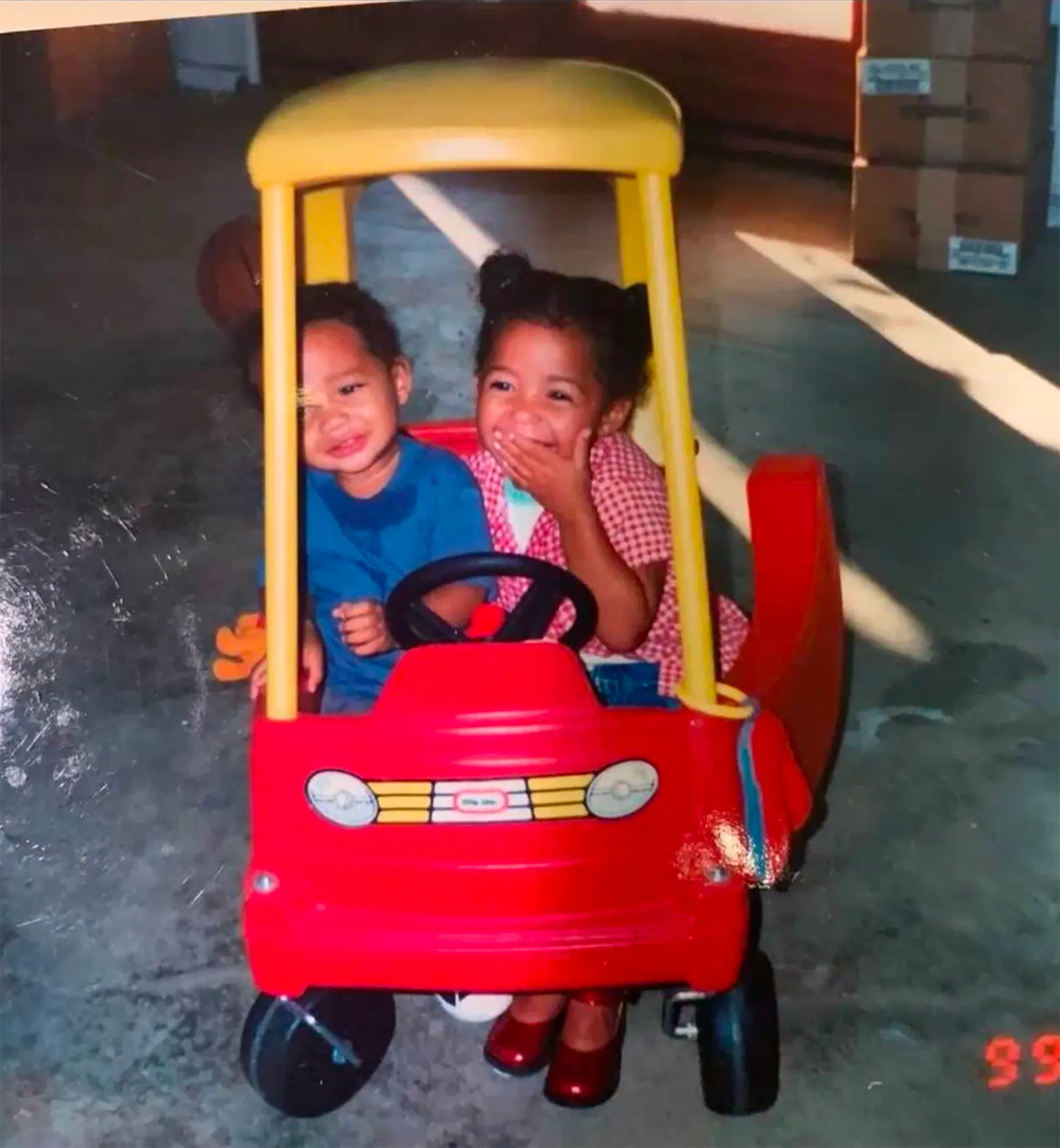A young Jordyn Woods and Jaden Smith sit in a red and yellow toy car.