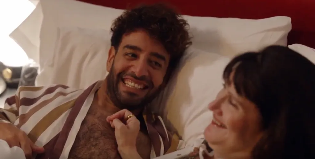 Mido lying in bed, smiling and looking at Debby.