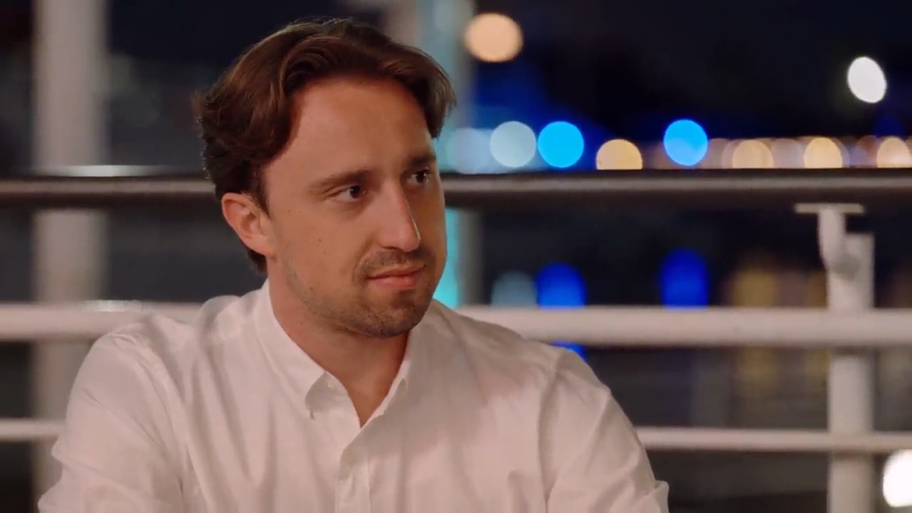 Thomas in a white shirt looking to the right.