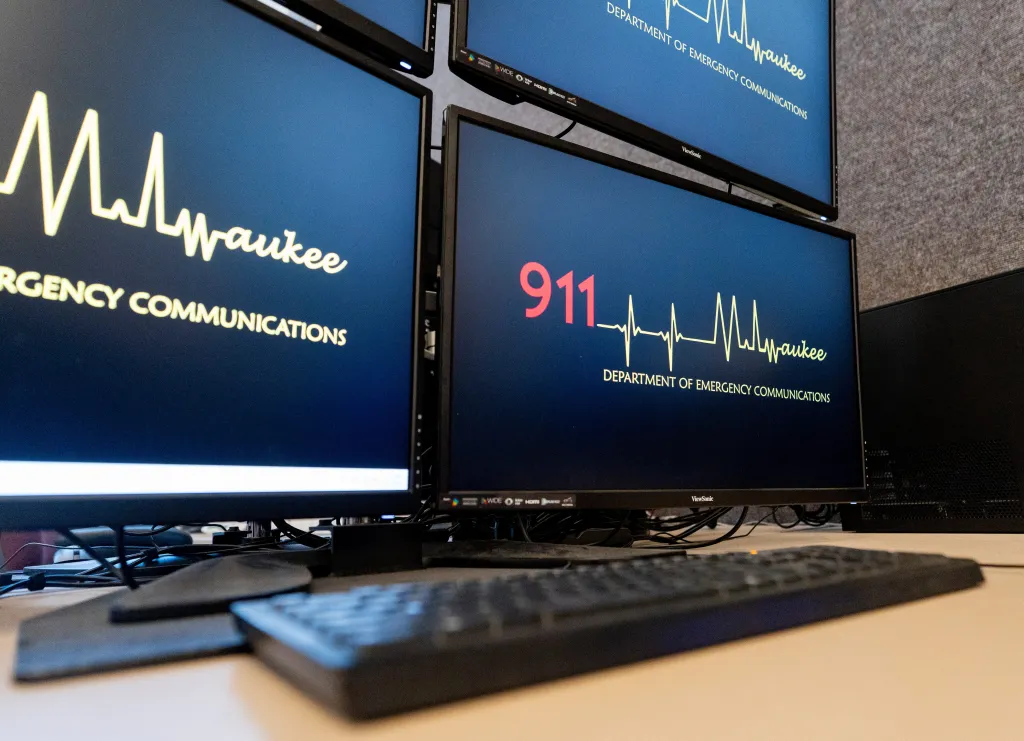 A 911 call station with multiple monitors displaying 
