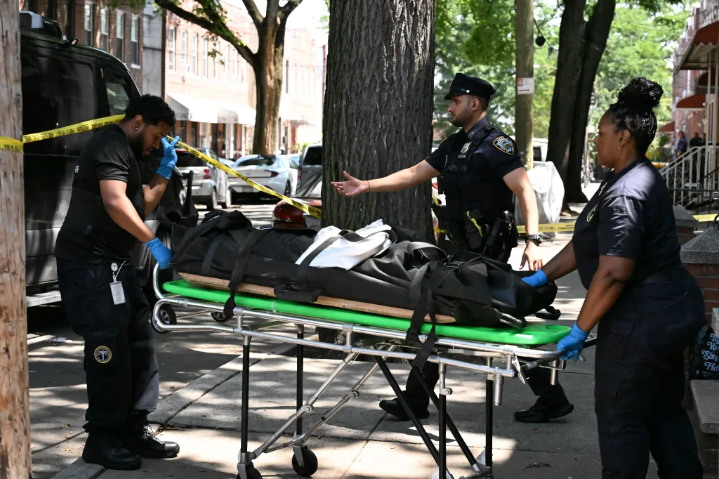 Medical Examiner personnel removing a deceased woman's body from a Brooklyn, New York street.