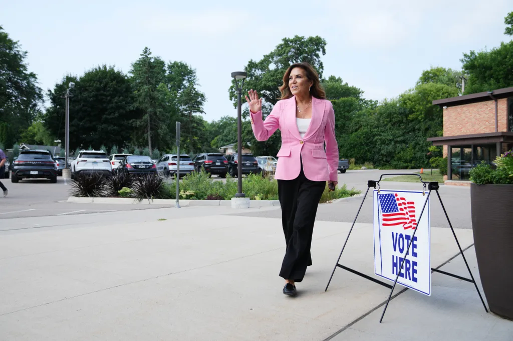 Michele Tafoya waves while walking past a 