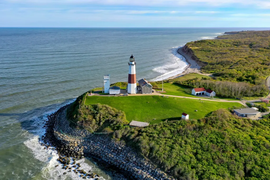 Montauk Lighthouse in Long Island, New York, with waves crashing on a rocky shore.