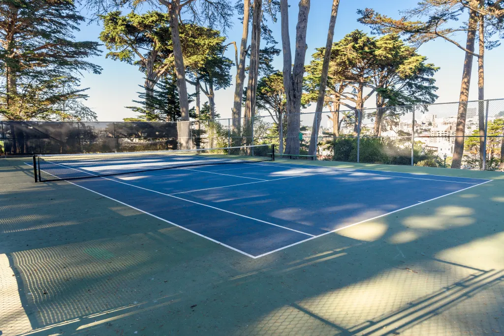 Deserted tennis court in a public park on a sunny autumn day.