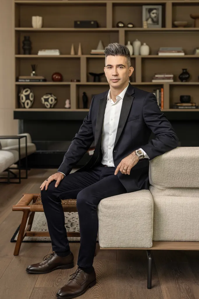 Yevgeny Dibrov wears a suit and sits on a couch