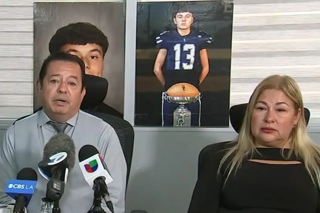 A man and a woman sitting at a table with microphones in front of them, with large photos of a young man behind them.