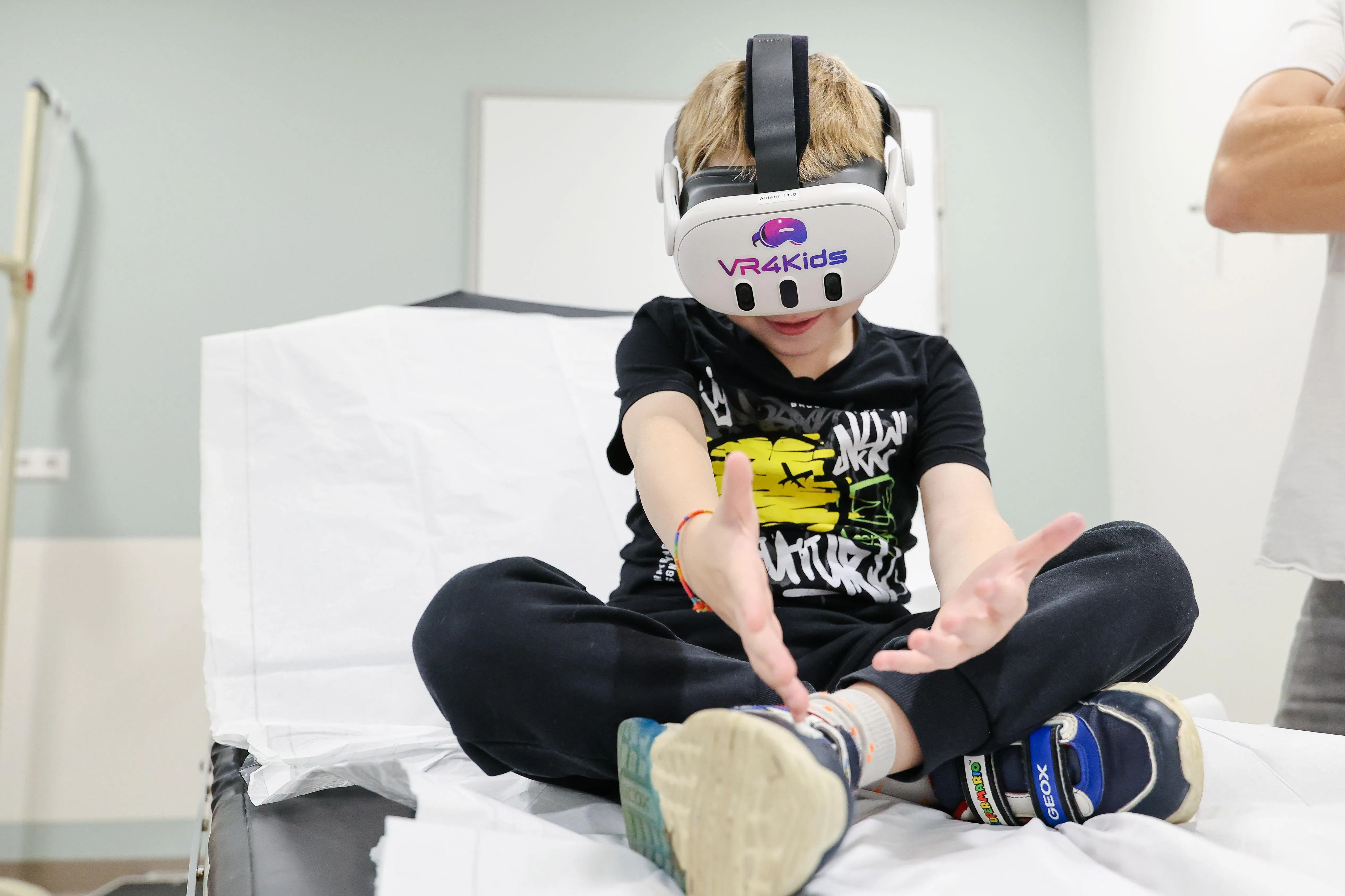 A child in all black clothing wears a white VR headset