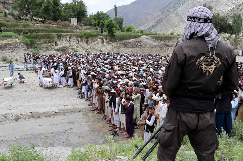 A Taliban personnel stands guard as Afghan men gather to offer funeral prayers for Pakistani airstrike victims at Mani village in Spera district, Khost province on June 10, 2026.