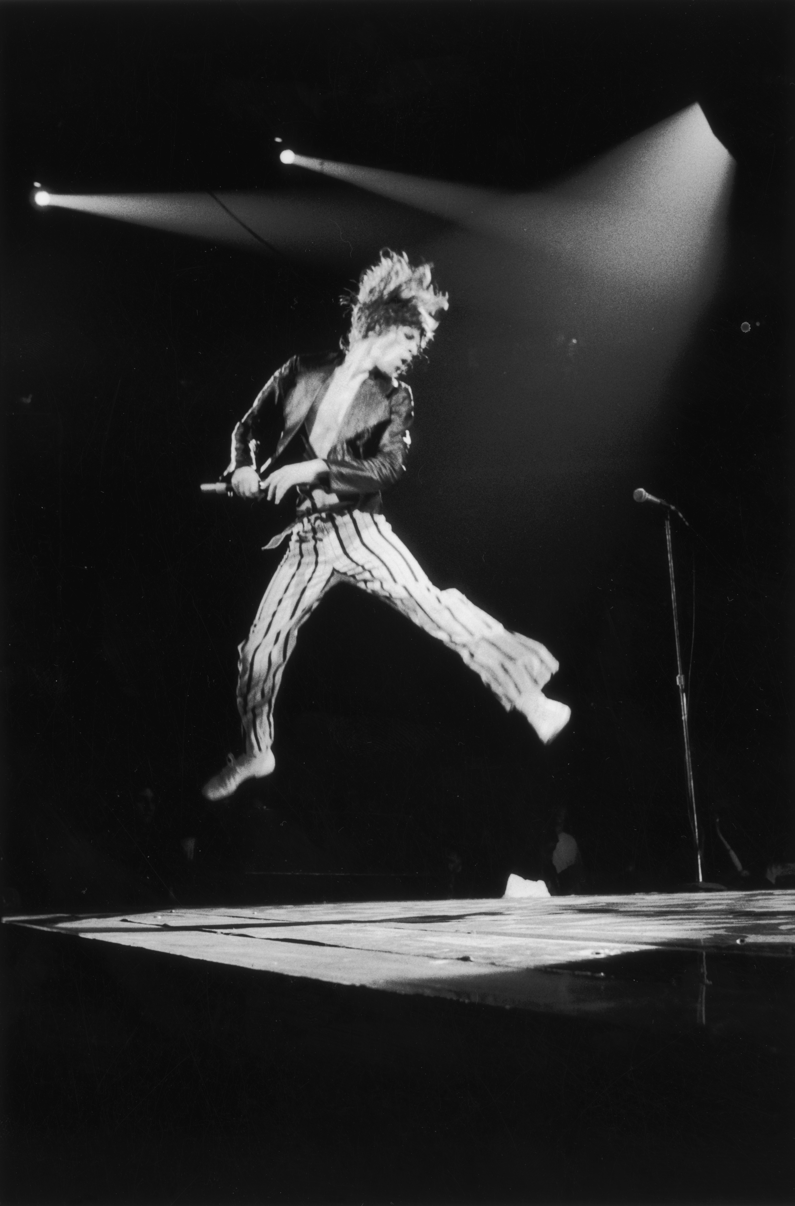 A spectacular leap from Mick Jagger on stage during the Rolling Stones' 1975 Tour of the Americas. 