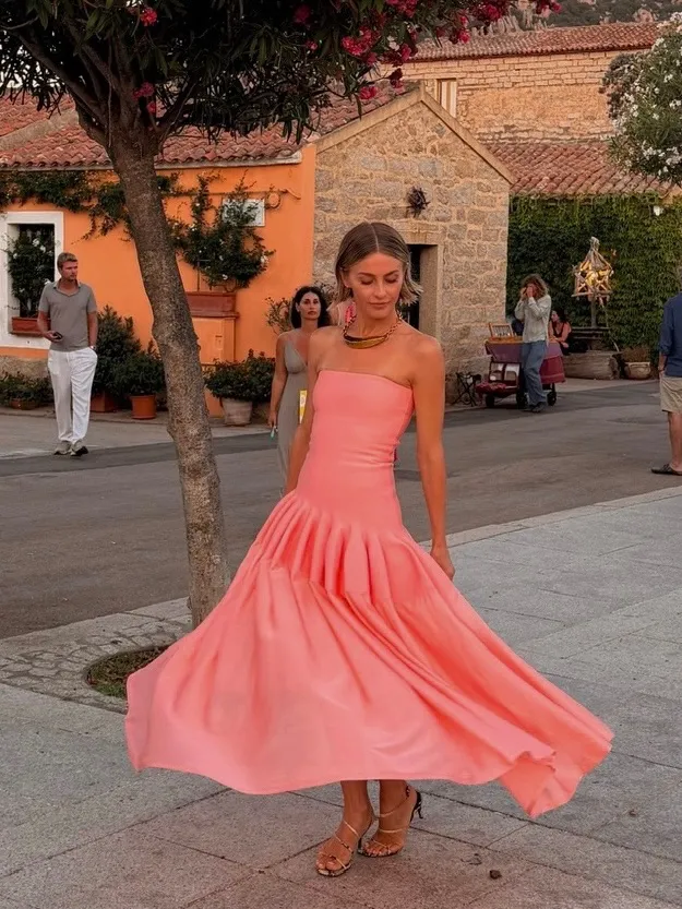 Julianne Hough in a coral strapless dress, gold necklace, and strappy heels.