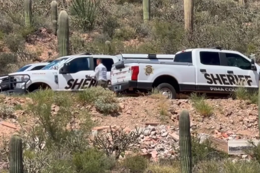 Sheriff vehicles on a dirt hill with cacti.
