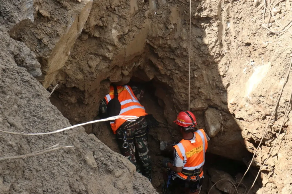 rescue workers taking part in a rescue operation near the tunnel of the Trishuli 3A Hydropower Project, following deadly flash floods and mudslides
