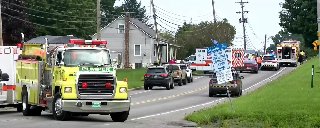 Emergency vehicles at the scene of an accident or incident on a rural road.
