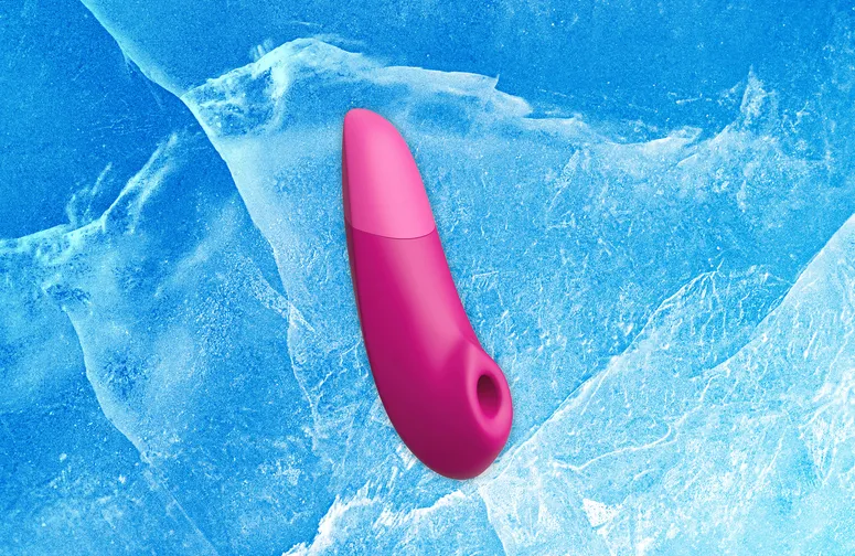 Womanizer Enhance, a pink curved vibrator. Background: blue ice texture.
