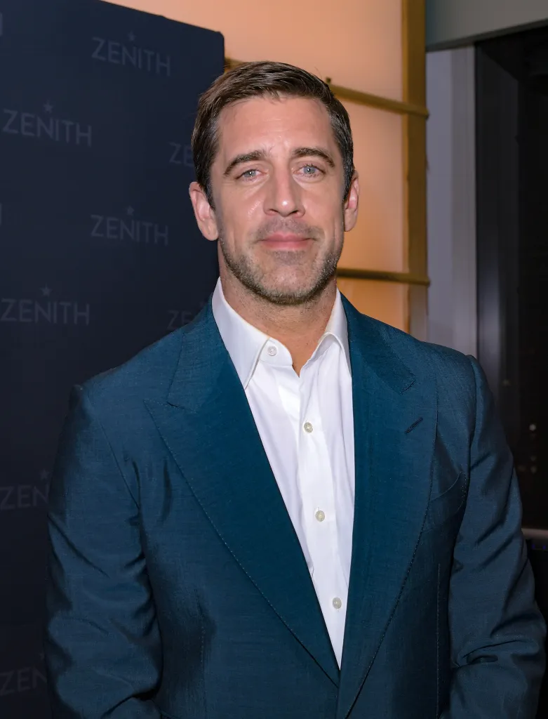 Aaron Rodgers in a dark suit jacket and white shirt.