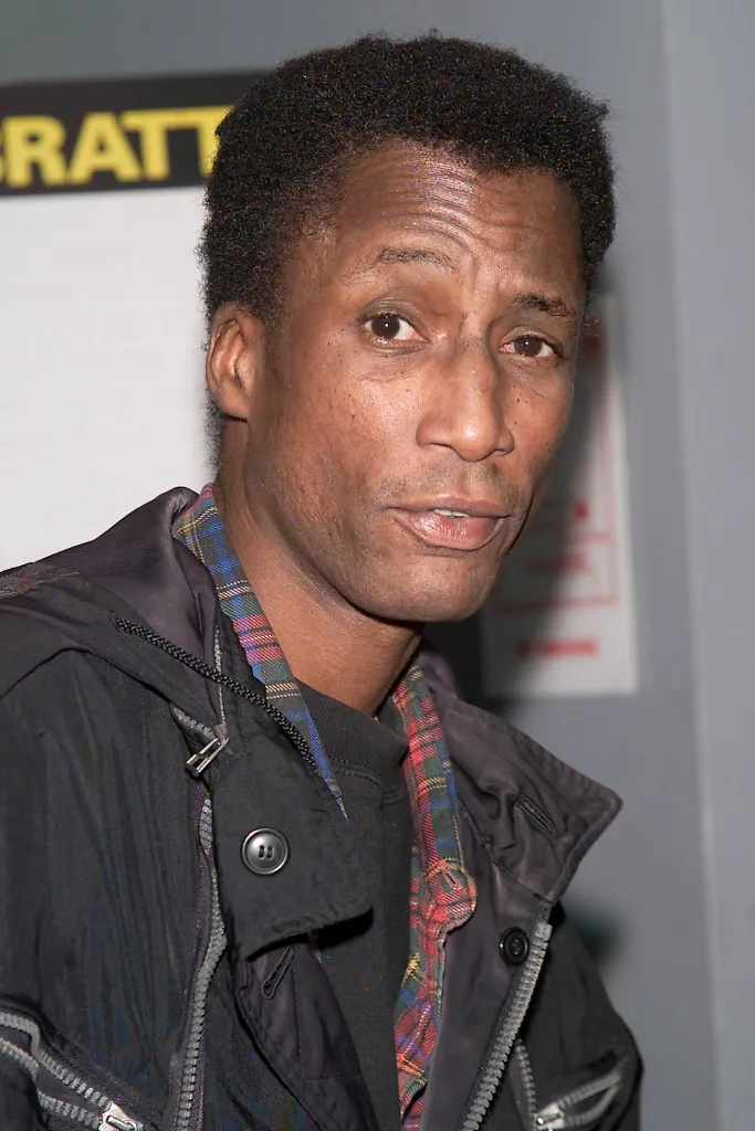 Headshot of actor Michael Wright wearing a dark jacket over a plaid shirt.