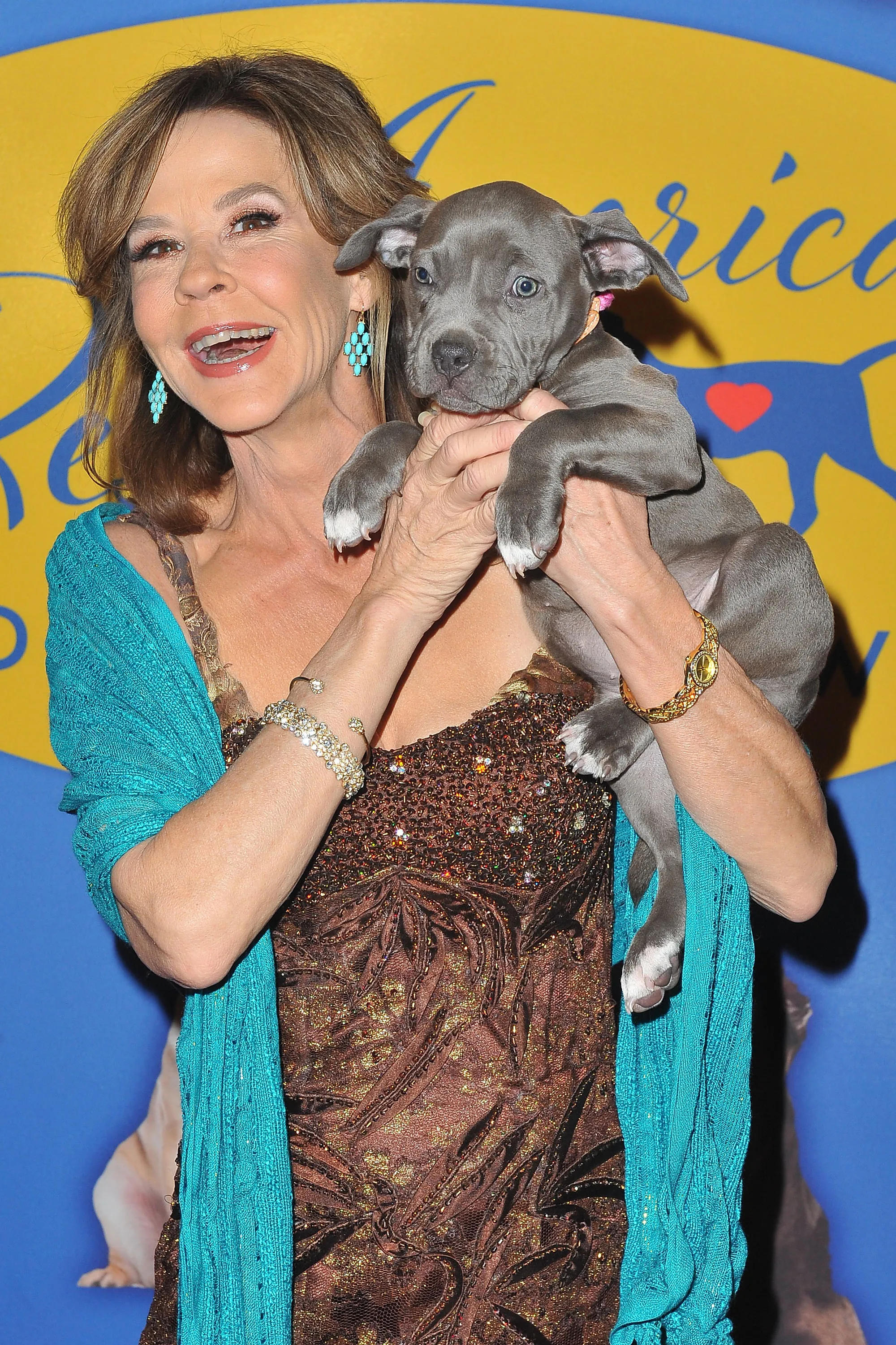 Actress Linda Blair holding a grey puppy.