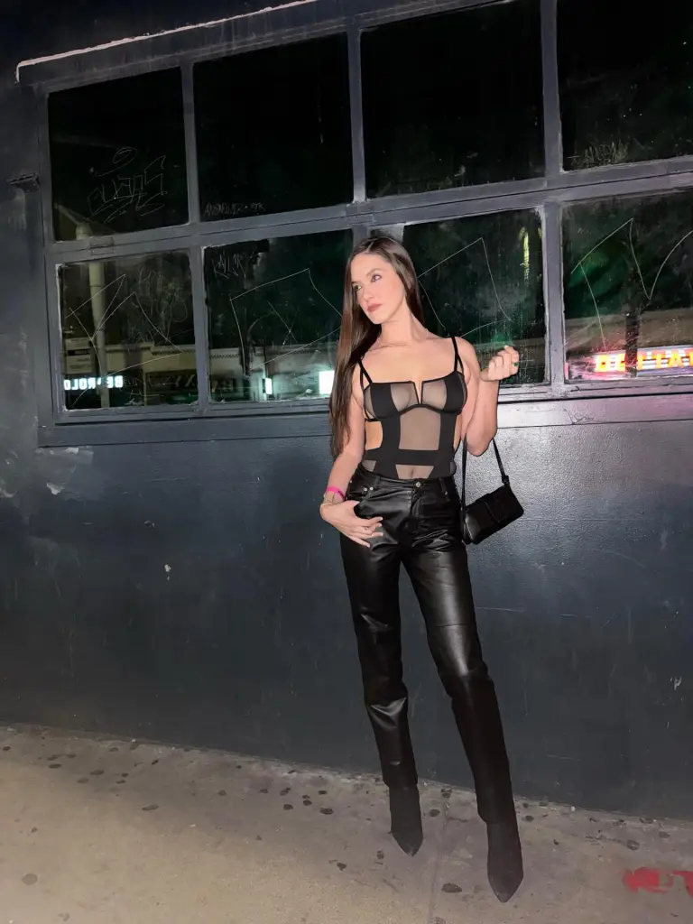 Alaia Baldwin wearing a black sheer bodysuit and black leather pants.
