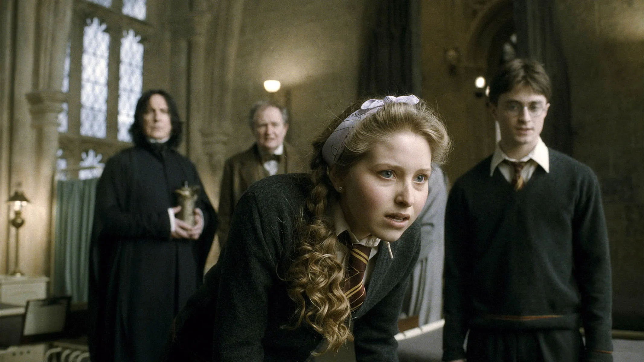 Jessie Cave as Lavender Brown with Daniel Radcliffe as Harry Potter, Alan Rickman as Severus Snape, and Jim Broadbent as Horace Slughorn.