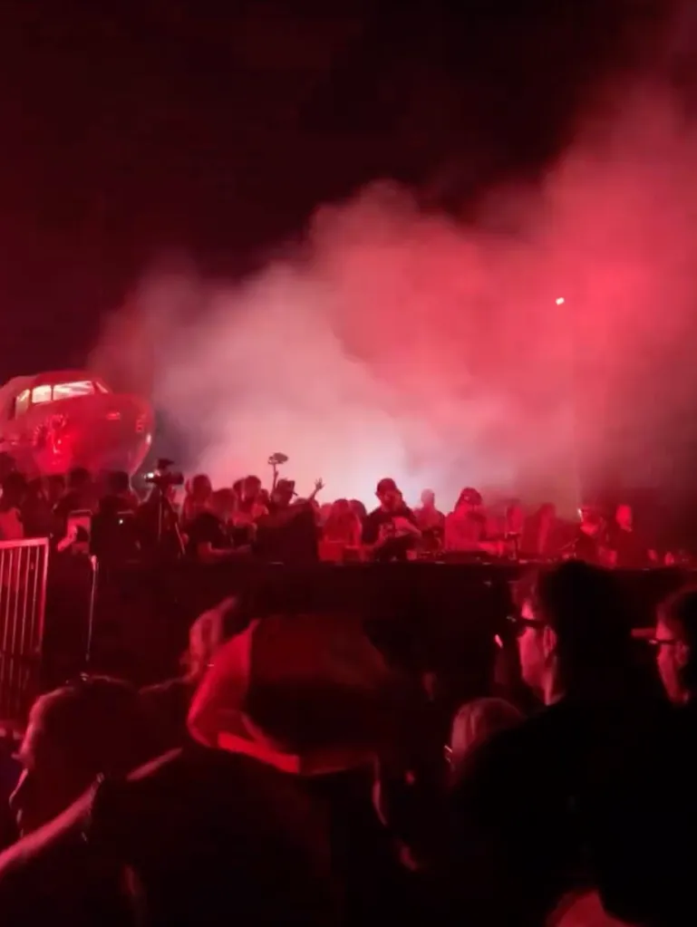 People at a Splash House event in front of a stage with red lights and smoke.