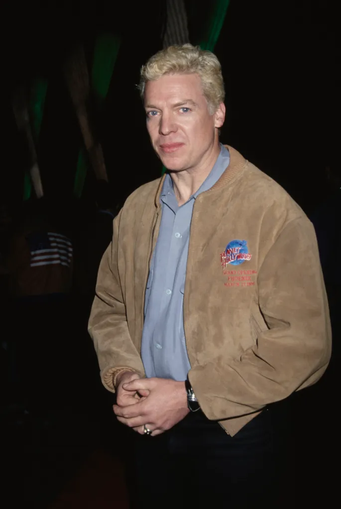 American actor Christopher McDonald wearing a suede jacket with the 'Planet Hollywood' logo.