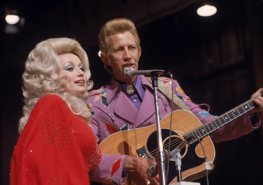 Dolly Parton and Porter Wagoner performing a duet on stage.