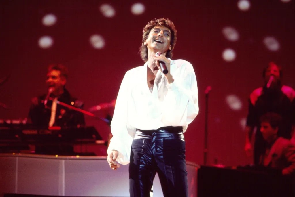 Barry Manilow performing onstage with his band.