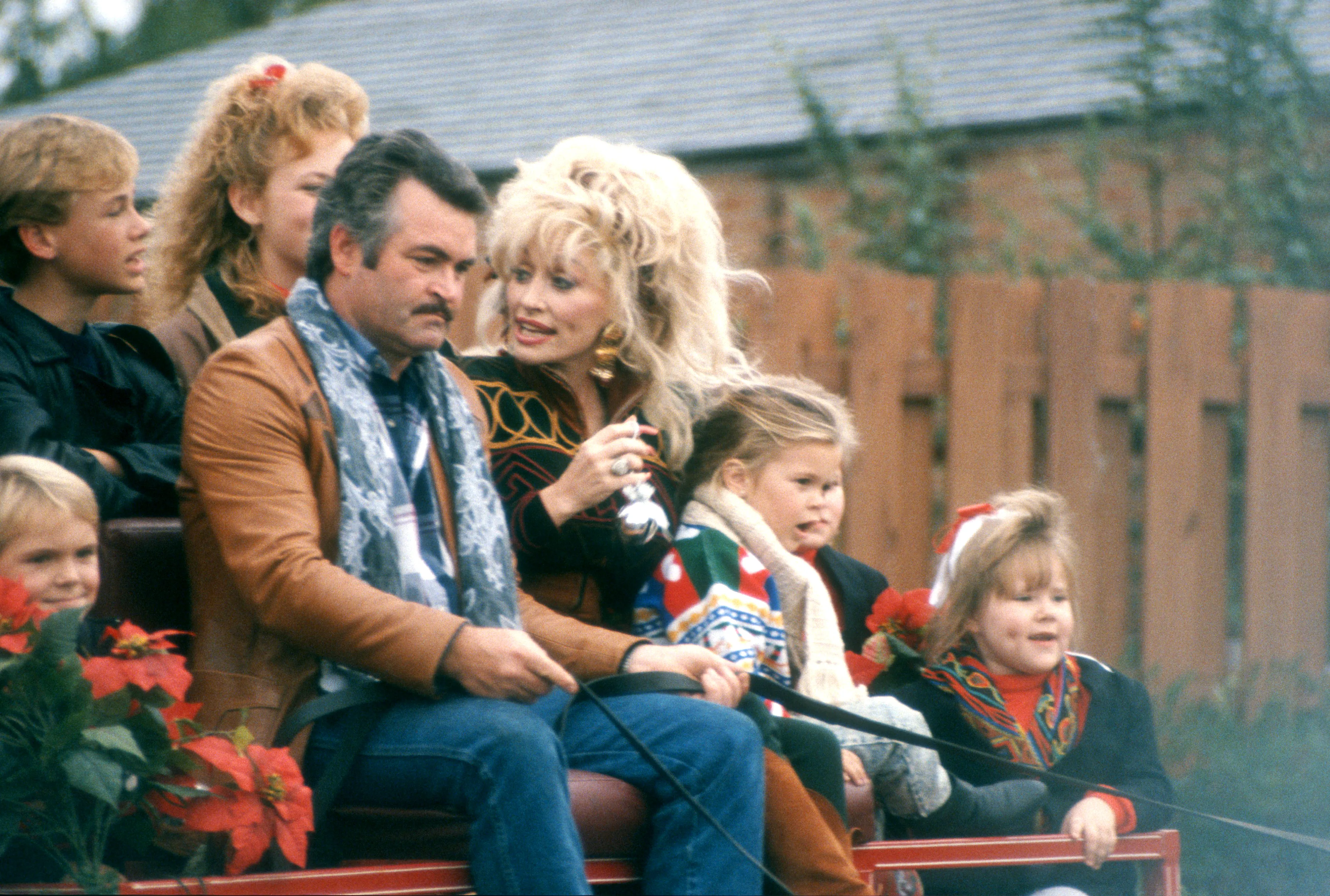 Dolly Parton and other passengers in a carriage at Dollywood Theme Park.