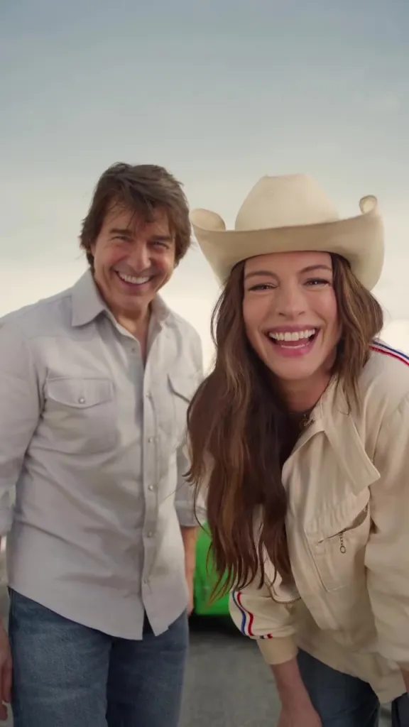 Anne Hathaway and Tom Cruise smile.