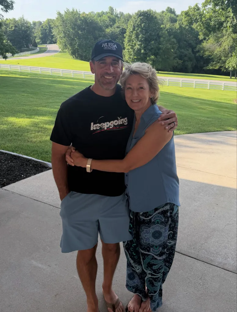 Aaron Rodgers with his arm around a woman.