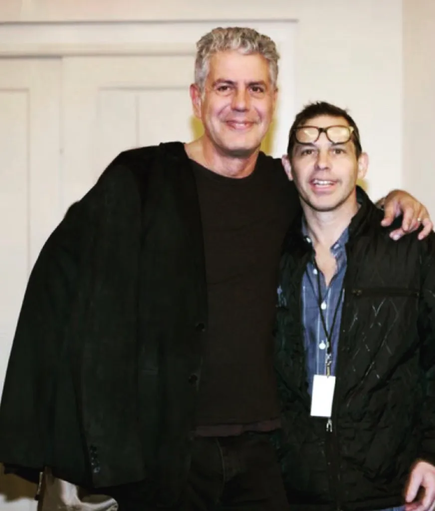 Anthony Bourdain and John Tesar posing together.