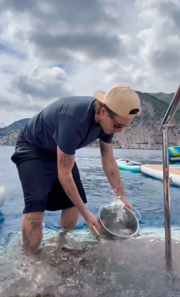 Brooklyn Beckham collecting seawater in a pot from a boat.