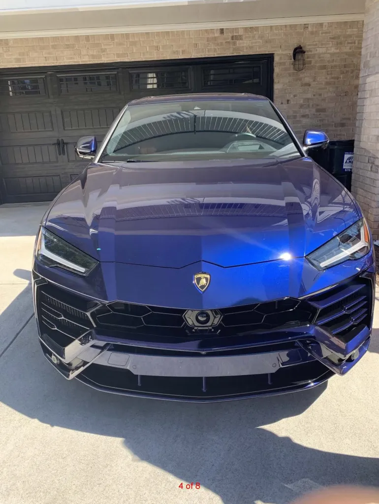 A blue 2019 Lamborghini Urus parked in a driveway.