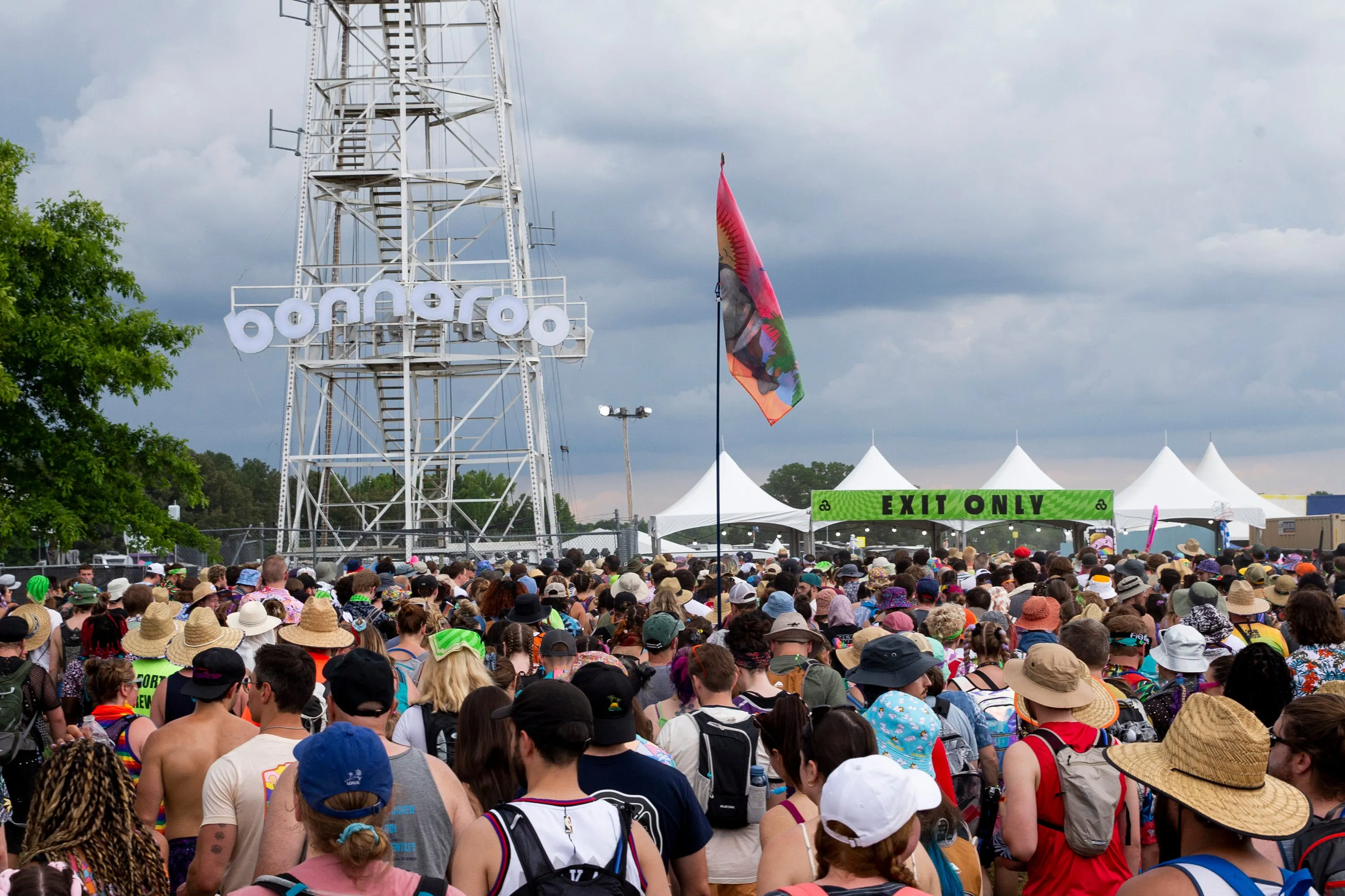 Attendees gather at the exit after Bonnaroo issued a weather evacuation for Centeroo as storm clouds can be seen in the distance on the first day of Bonnaroo near Manchester, Tenn., on June 15, 2023.