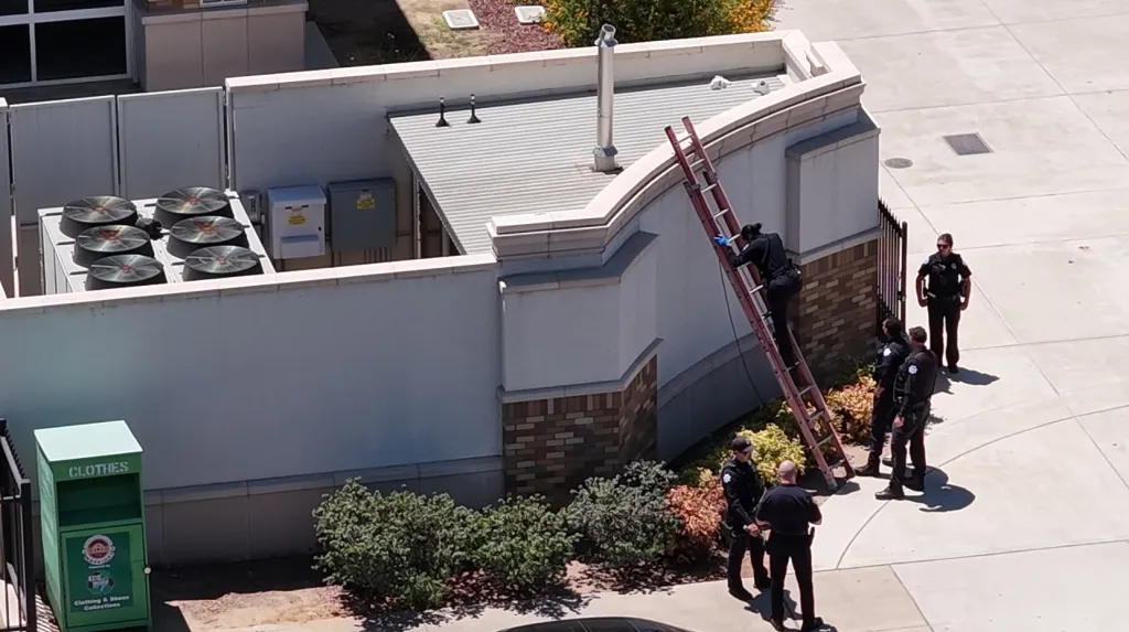 Authorities investigating a body found on the roof of a building at Fresno High School.