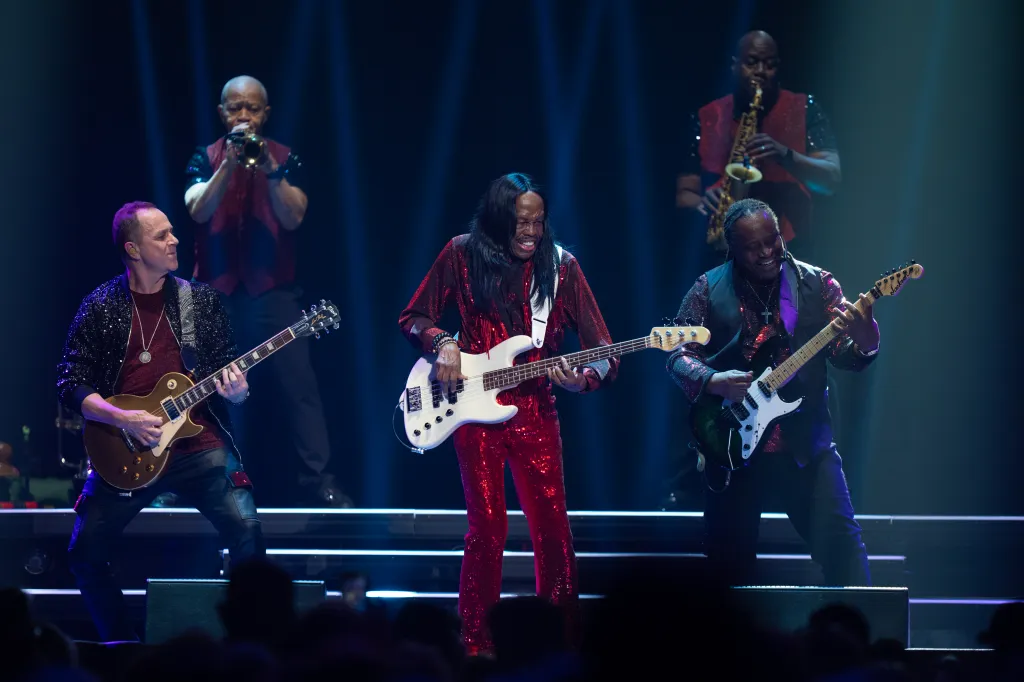Bassist Verdine White, center, flanked by guitarists, performs with Earth, Wind & Fire.