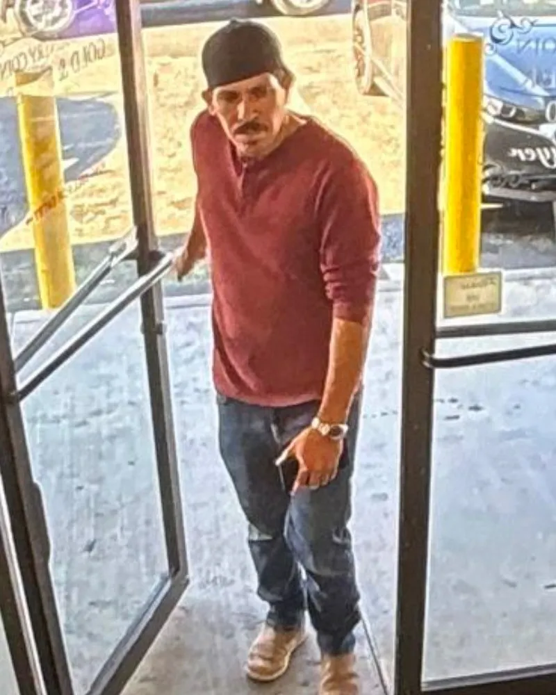 David Alejandro Gomez Sanchez, accused of a burglary spree, stands at a doorway.