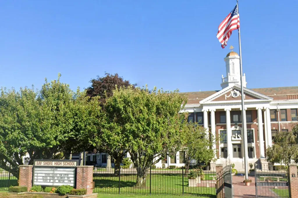 Bay Shore High School building with an American flag flying on a pole in front.