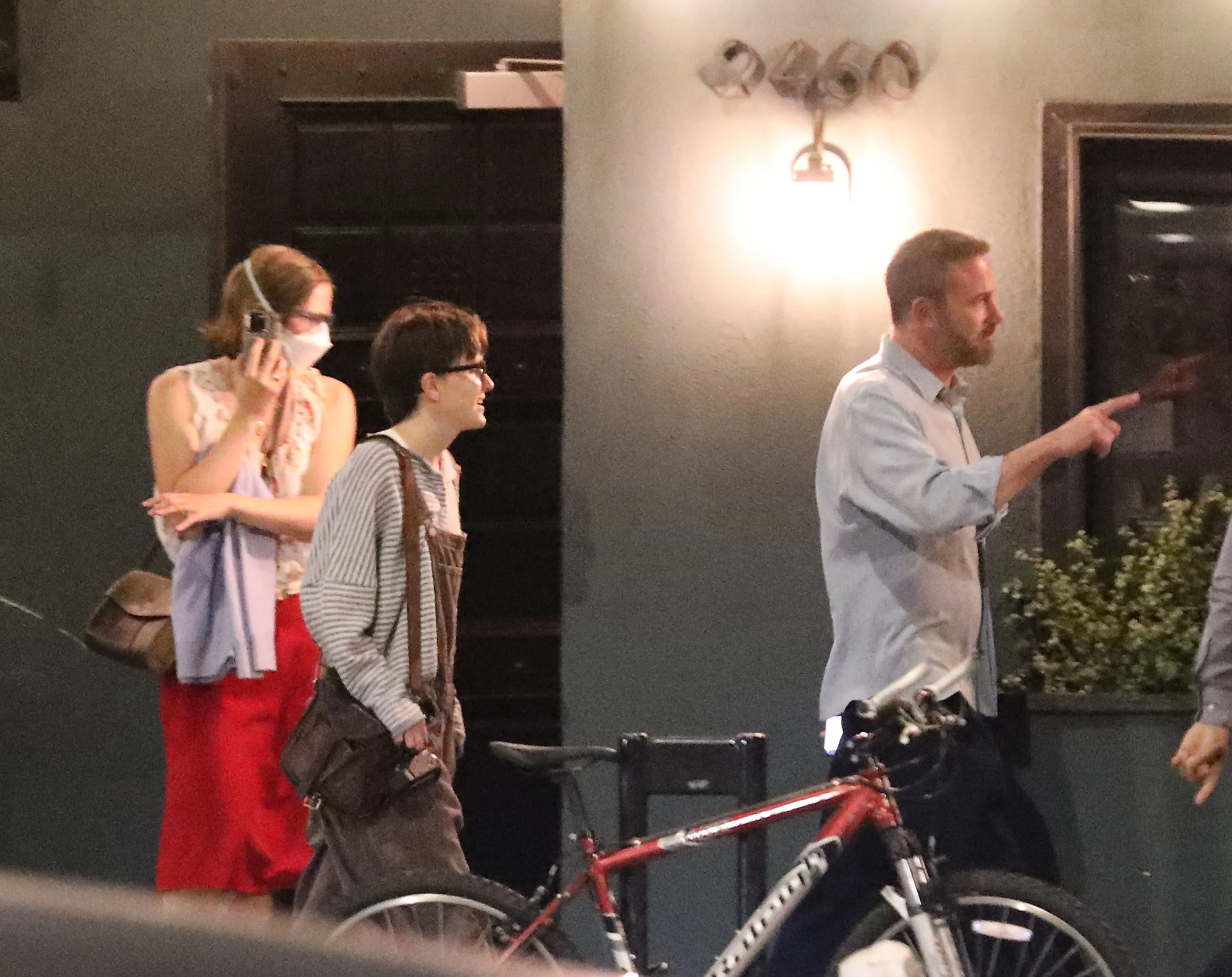 Ben Affleck and his child Violet walking out of a restaurant, with Violet wearing a mask.