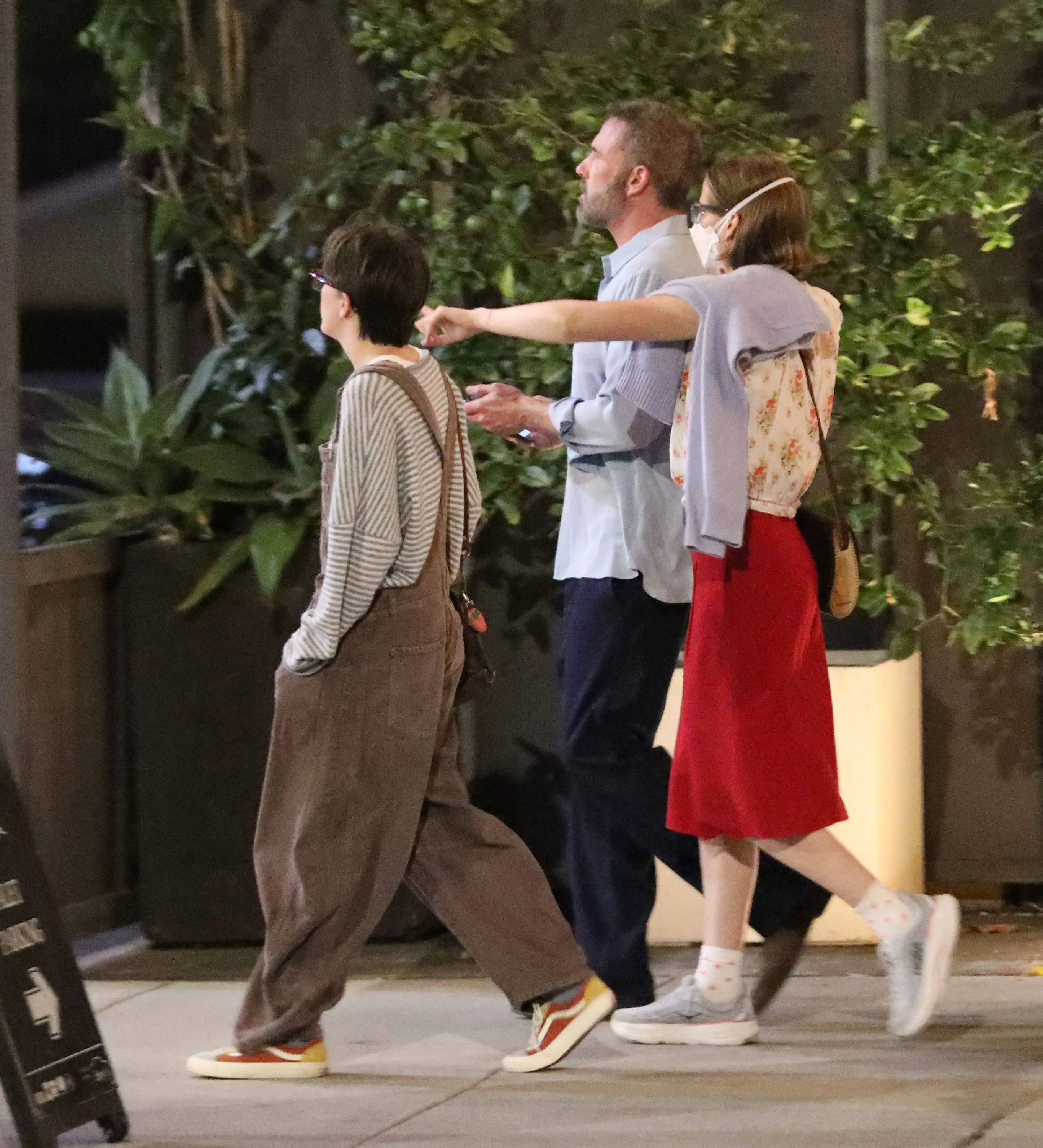 Ben Affleck walking with his kids, including his masked daughter, to a restaurant.