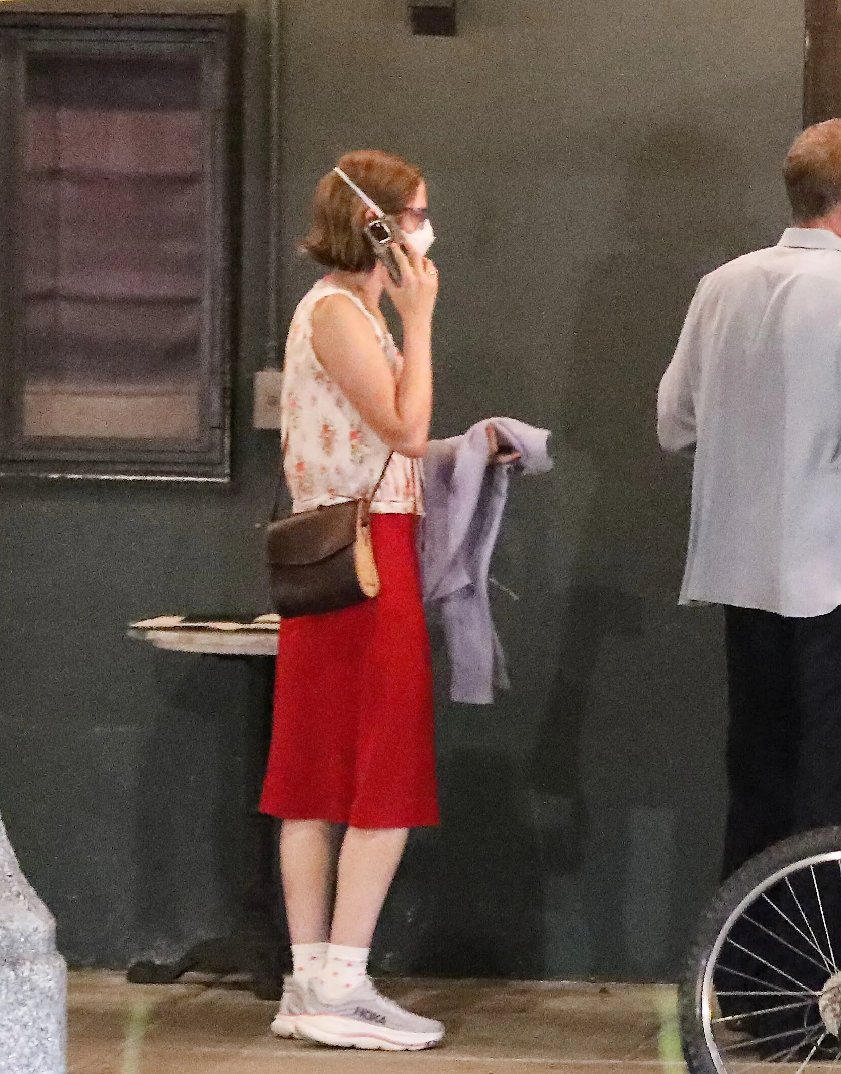 Violet Affleck, masked, talking on the phone.