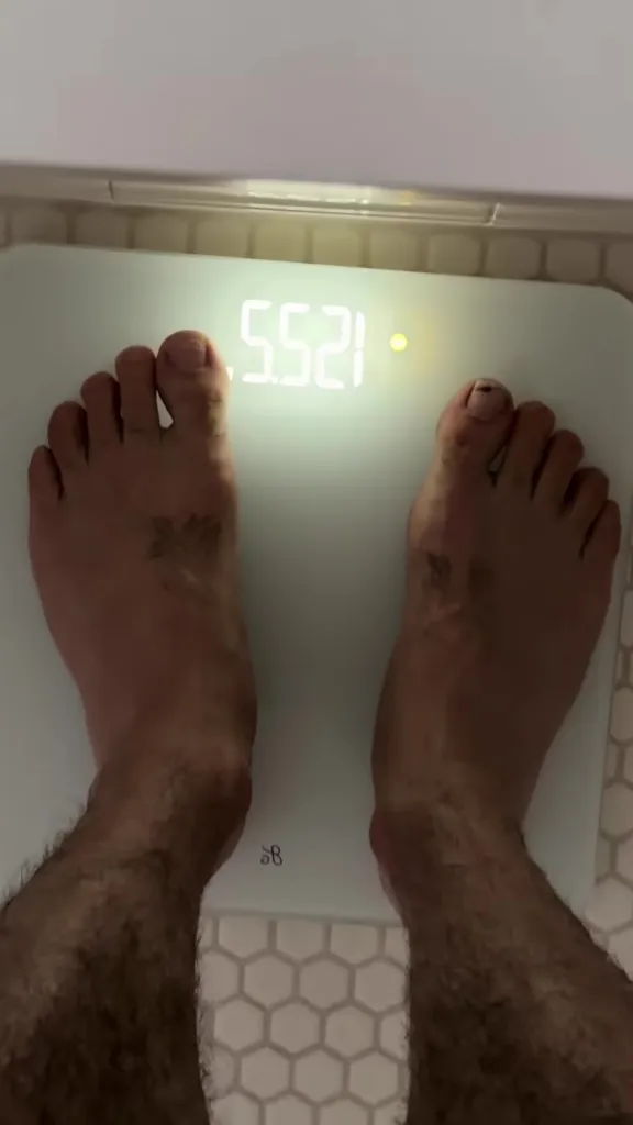 A person's feet on a scale showing 5.521.
