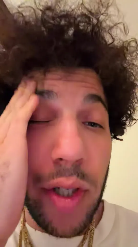 Benny Blanco covering his face with his hand.