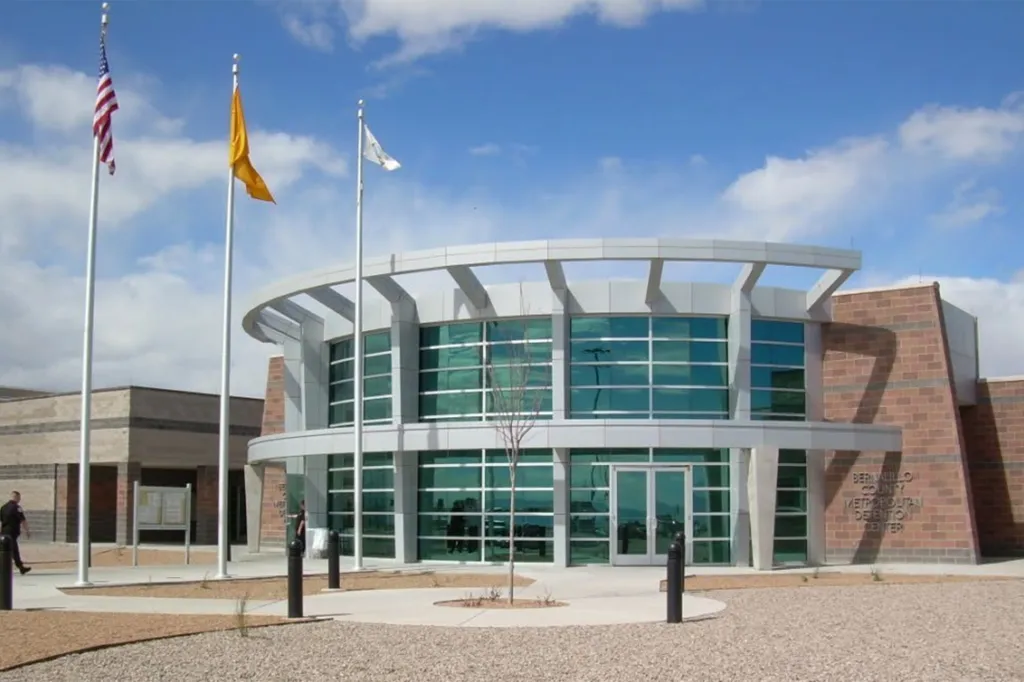 The Metropolitan Detention Center (MDC) of Bernalillo County building under a blue sky.